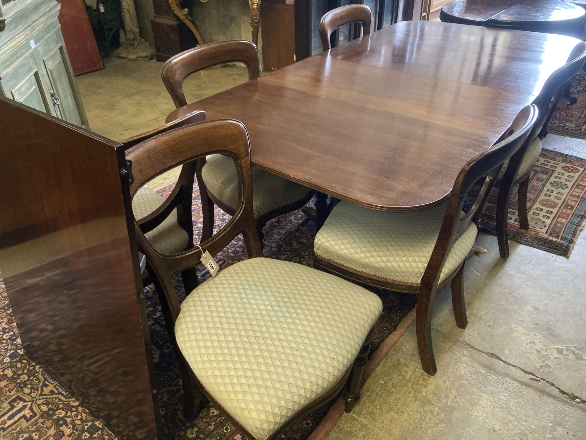 A George III style mahogany twin pillar extending dining table, extended 270cm (one spare leaf), together with a set of six Victorian o